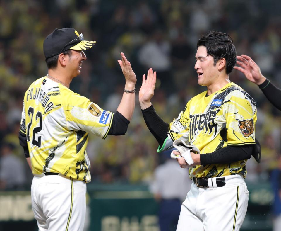 １１回、サヨナラ二塁打を放った高寺（右）とタッチを交わす藤川監督（撮影・立川洋一郎）