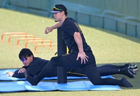 外野でストレッチする佐藤輝と森下（撮影・飯室逸平）