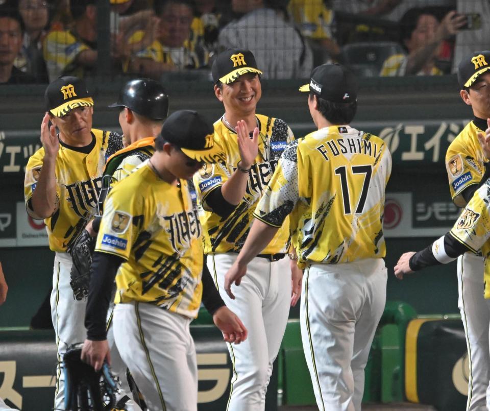 笑顔でナインとタッチを交わす藤川監督（撮影・飯室逸平）