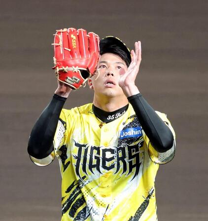 ６回表を投げ終わり、グラブをたたきながらベンチへ引き揚げる才木（撮影・立川洋一郎）