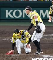 ９回、マウンドで立ち上がれない才木を佐藤輝が手を貸す（撮影・山口登）