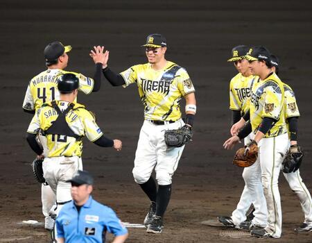 　完封勝利を挙げた村上（左奥）と勝利のハイタッチを交わす佐藤輝（撮影・立川洋一郎）