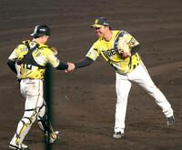 ９回、完封勝利を飾り坂本（左）と握手を交わす村上（撮影・立川洋一郎）