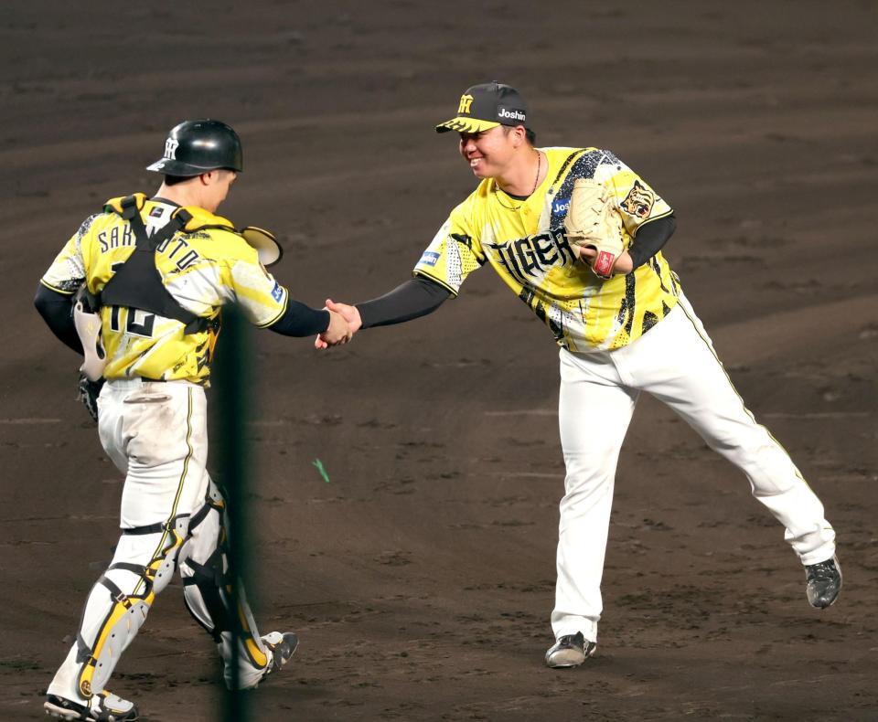 ９回、完封勝利を飾り坂本（左）と握手を交わす村上（撮影・立川洋一郎）