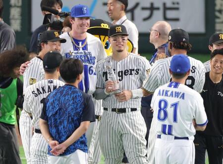 トロフィーを持ち、記念撮影する佐藤輝（中央）＝撮影・西岡正