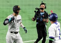 １回、先制ソロを放ち笑顔で生還する佐藤輝（左）＝撮影・山口登