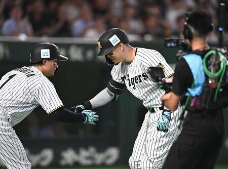 １回、先制の右越えソロを放ち森下（左）とタッチを交わす佐藤輝（撮影・開出牧）