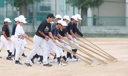 選手たちと整備をする玉置隆コーチ（手前）＝撮影・中田匡峻