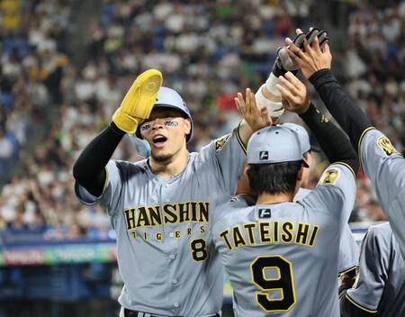 ７回、生還しナインに迎えられる佐藤輝（撮影・田中太一）