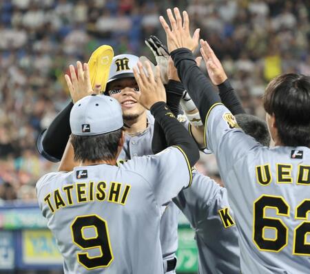 ７回、生還しナインに迎えられる佐藤輝（撮影・田中太一）