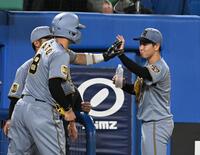 ３回終了後、逆転の２点適時打を放った佐藤輝（左）とタッチを交わす下村（撮影・堀内翔）