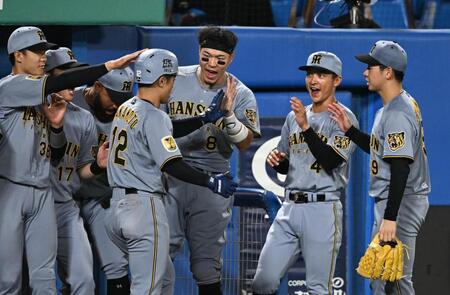 ４回、ソロを放った坂本（１２番）を迎える佐藤輝（中央）＝撮影・堀内翔