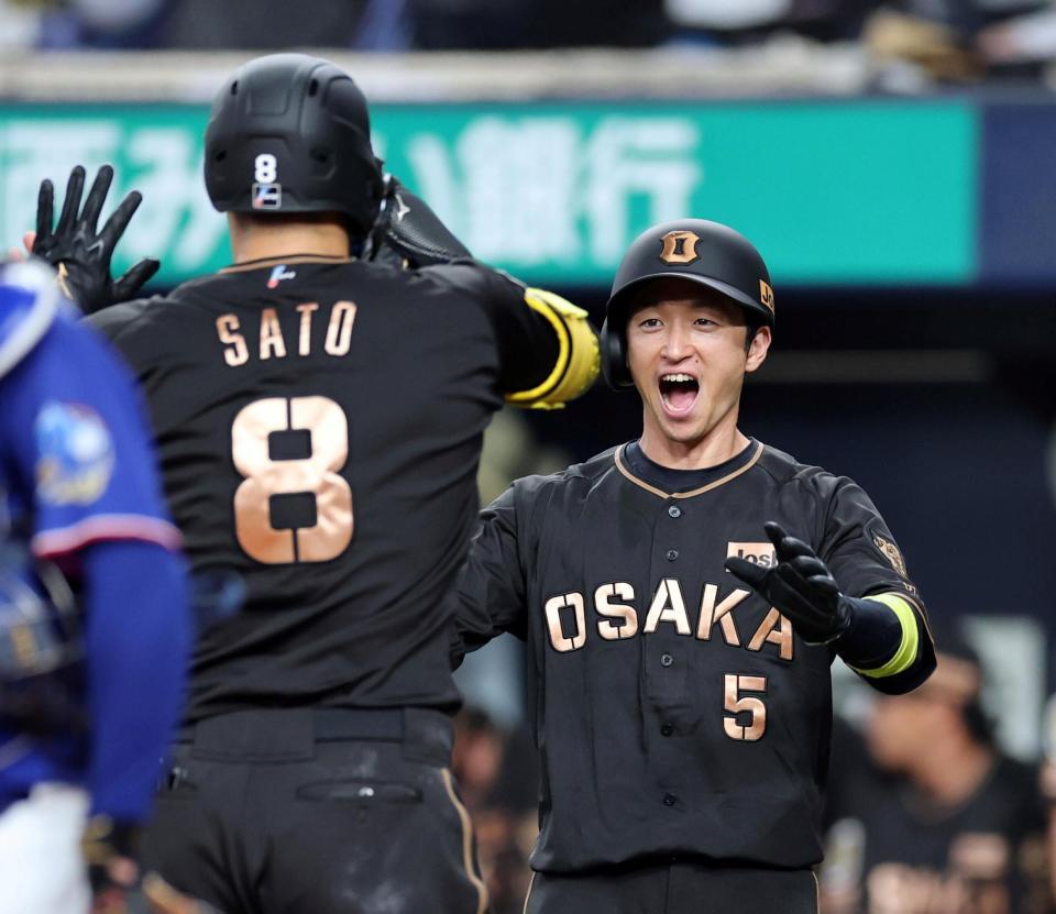 １回、先制２ランを放った佐藤輝を迎える近本（撮影・山口登）