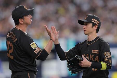 勝利後、藤川監督（左）とタッチを交わす近本（撮影・西田忠信）