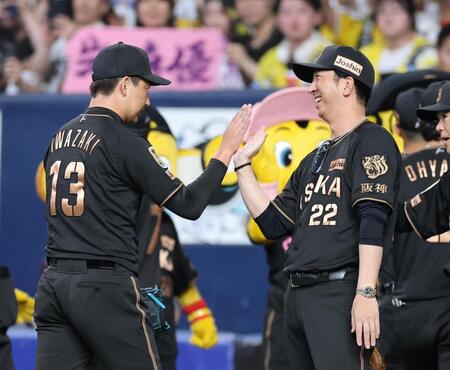 笑顔で岩崎（左）とタッチする藤川監督（撮影・山口登）
