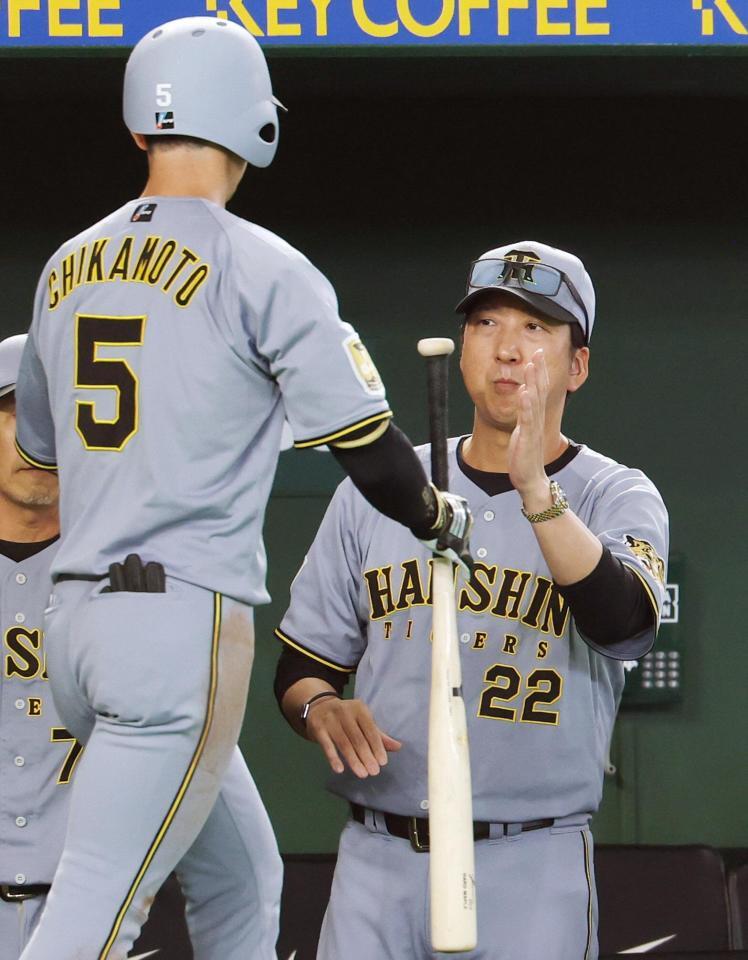 ３回表、先制ソロを放った近本（左）を迎える藤川監督