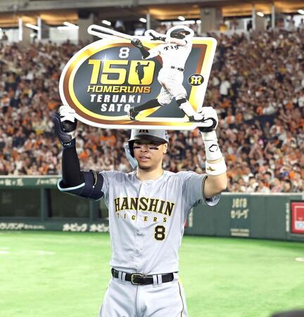 ７回、プロ通算１５０号を放ち、ボードを掲げる佐藤輝（撮影・田中太一）