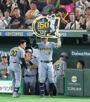 ７回、右中間にプロ入り通算１５０号となるソロを放ちボードを掲げる佐藤輝（撮影・金田祐二）