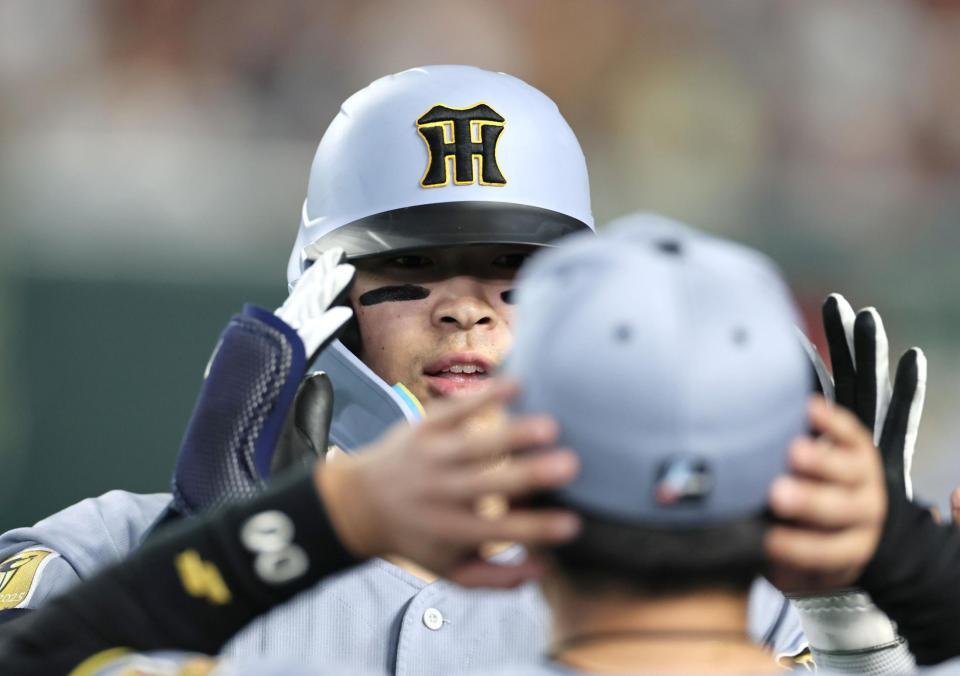 ３回、ソロを放った佐藤輝は元山（手前）に迎えられヘルメットに手をそえる（撮影・田中太一）