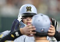 ３回、ソロを放った阪神・佐藤輝明は阪神・元山飛優（手前）に迎えられヘルメットに手をそえる＝１２日