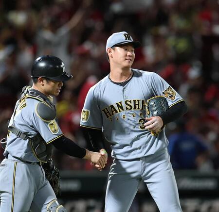 ９回、最後を締めた及川は坂本（左）と握手する（撮影・北村雅宏）