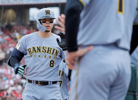 広島戦の１回、先制２ランを放ち、ナインとタッチを交わす佐藤輝（撮影・西田忠信）＝１６日