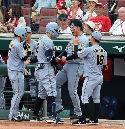 広島戦の１回、佐藤輝は先制２ランを放ち森下らナインに迎えられる（撮影・山口登）＝１６日