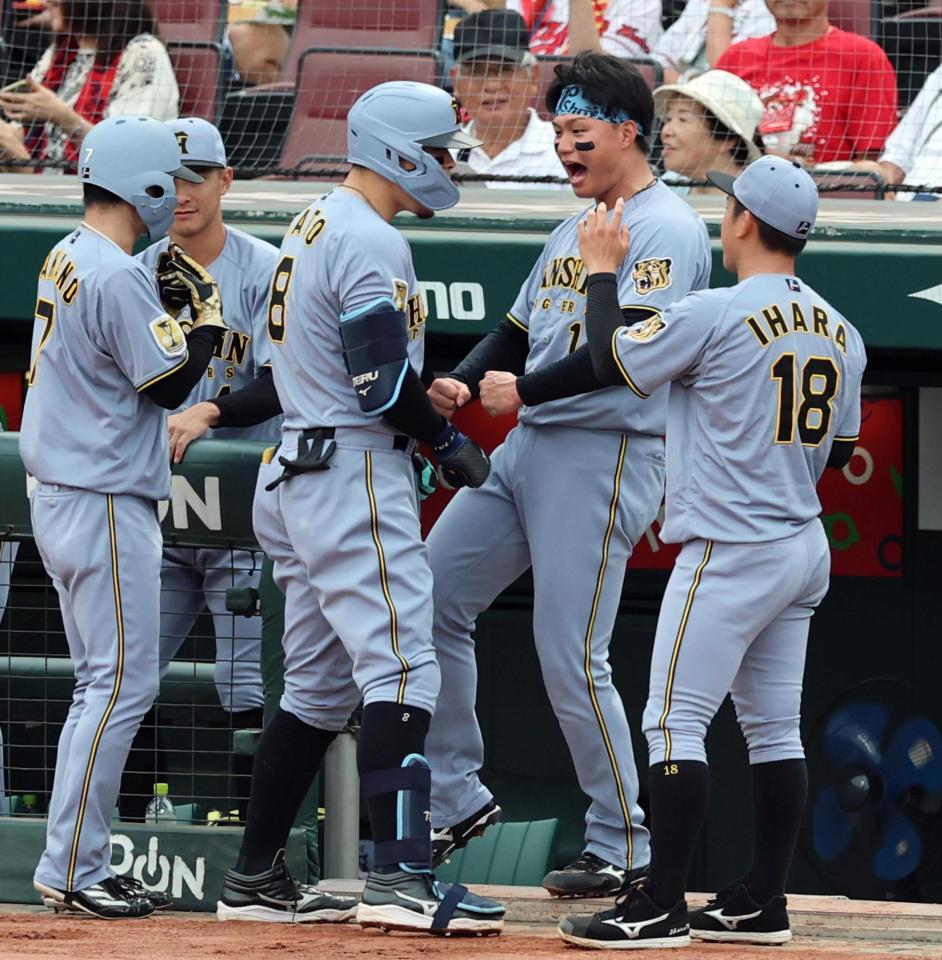 　１回、佐藤輝は先制２ランを放ち、森下らナインに迎えられる（撮影・山口登）