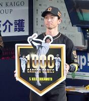 　記念ボードを掲げる近本