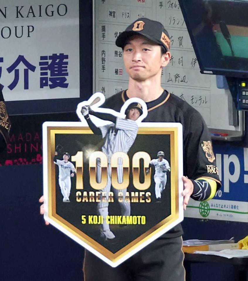 　記念ボードを掲げる近本