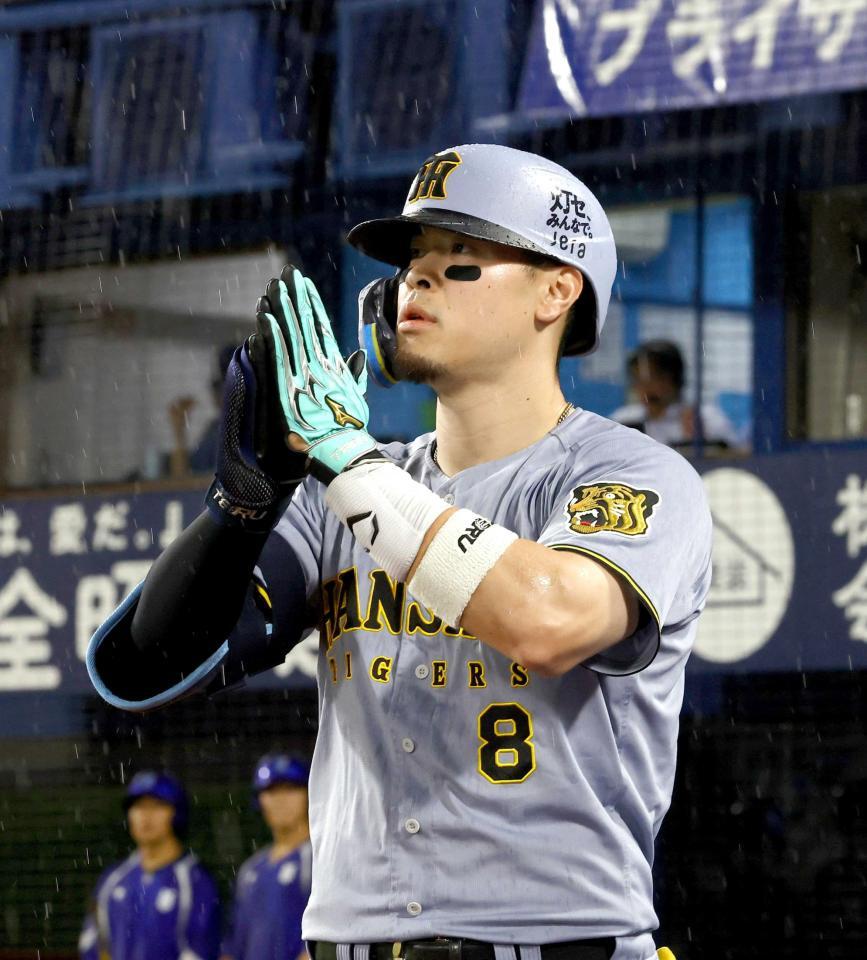 　８回、３０号ソロを放った佐藤輝はベンチ前で手を合わせる（撮影・山口登）
