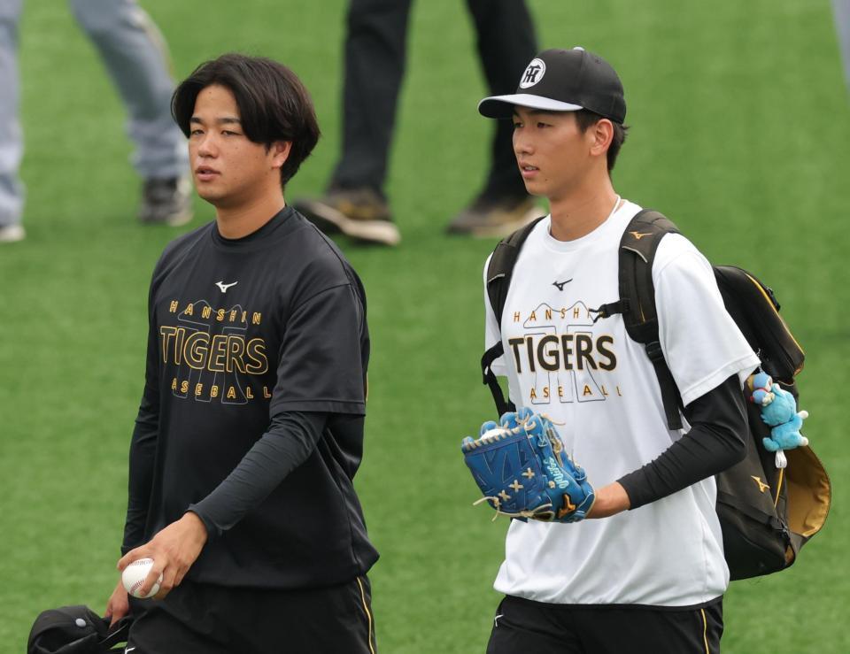 阪神・今朝丸（右）と話しながら練習に向かう阪神・高橋＝横浜スタジアム（撮影・西岡正）