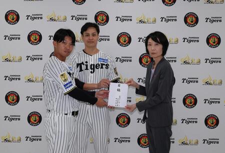 熊本県大阪事務所の山田所長に目録を手渡す大竹（中央）と島田（左）＝球団提供
