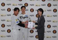 熊本県大阪事務所の山田所長に目録を手渡す大竹（中央）と島田（左）＝球団提供