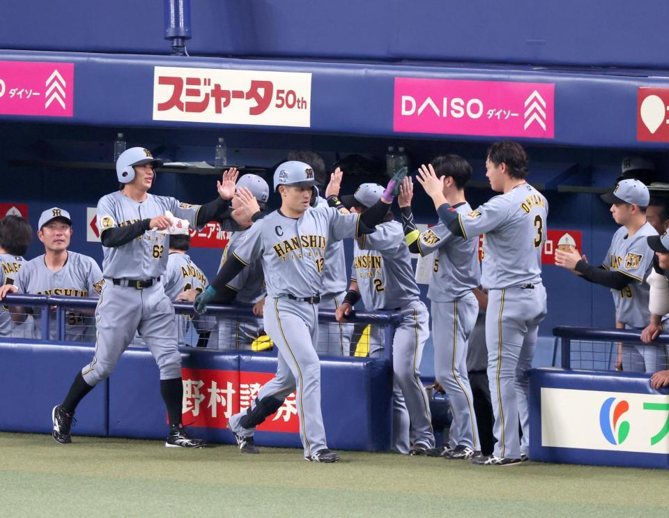 ８回、逆転２ランを放ち迎えるナインとタッチを交わす坂本（中央）＝撮影・立川洋一郎