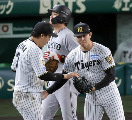 　坂本（奥）を一ゴロに打ち取って試合終了。ウイニングボールを大山（左）から受け取る工藤（撮影・立川洋一郎）