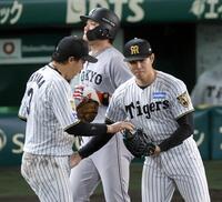 　坂本（奥）を一ゴロに打ち取って試合終了。ウイニングボールを大山（左）から受け取る工藤（撮影・立川洋一郎）