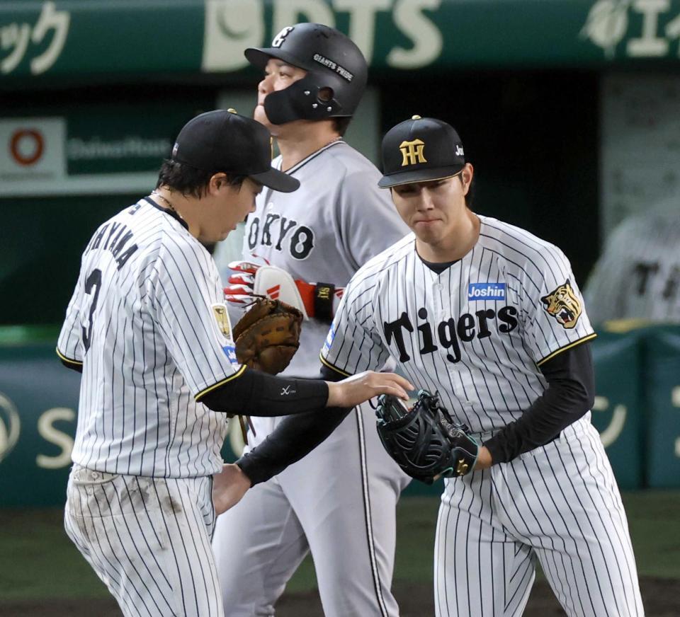 　坂本（奥）を一ゴロに打ち取って試合終了。ウイニングボールを大山（左）から受け取る工藤（撮影・立川洋一郎）