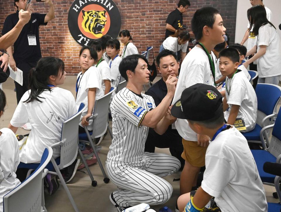 　子どもたちにサインする（中央）＝撮影・飯室逸平