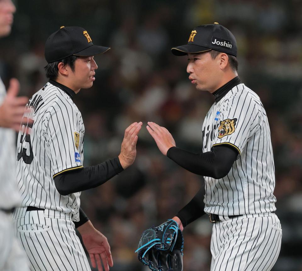 ８回を投げ終えた岩崎（右）を迎える才木（撮影・西田忠信）