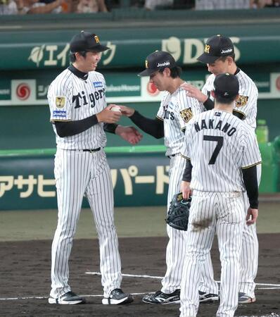 工藤（中央）からウイニングボールを手渡され笑顔を見せる才木（左）＝撮影・立川洋一郎