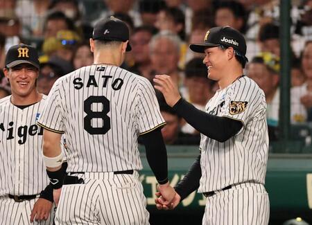 ３回、守備から戻る佐藤輝を迎える森下（撮影・田中太一）