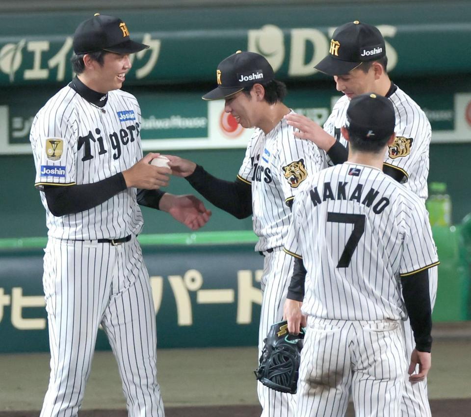 工藤（中央）からウイニングボールを手渡され笑顔を見せる才木（左）＝撮影・立川洋一郎