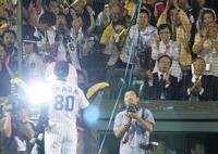 　リーグ優勝を決め、お立ち台に立つ岡田監督に拍手を送る母・サカヨさん＝２００５年９月