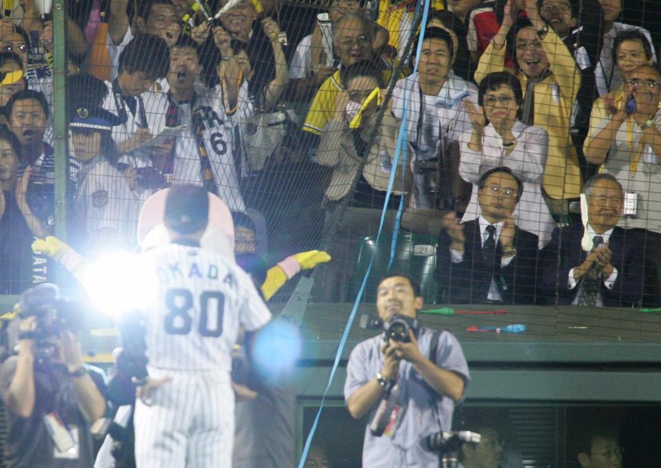 　リーグ優勝を決め、お立ち台に立つ岡田監督に拍手を送る母・サカヨさん＝２００５年９月