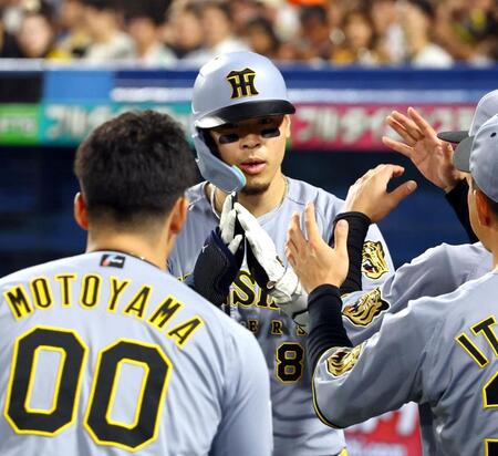 ３回、佐藤輝はソロを放ち生還しナインに迎えられる（撮影・山口登）