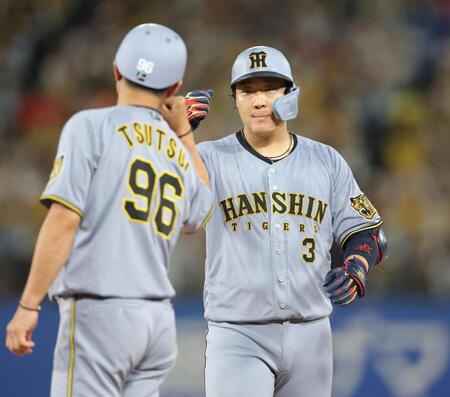 ９回、中前適時打を放ち、筒井コーチ（左）とタッチを交わす大山（撮影・西岡正）