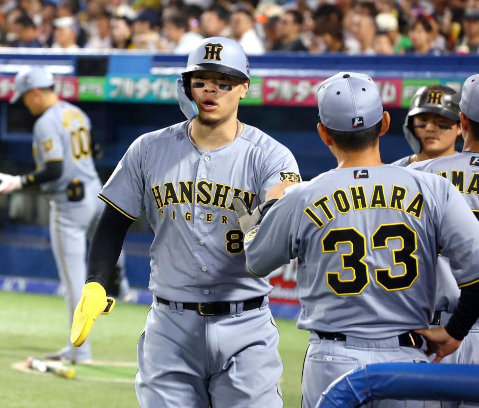 １回、佐藤輝は前川の犠飛で生還いナインに迎えられる（撮影・山口登）