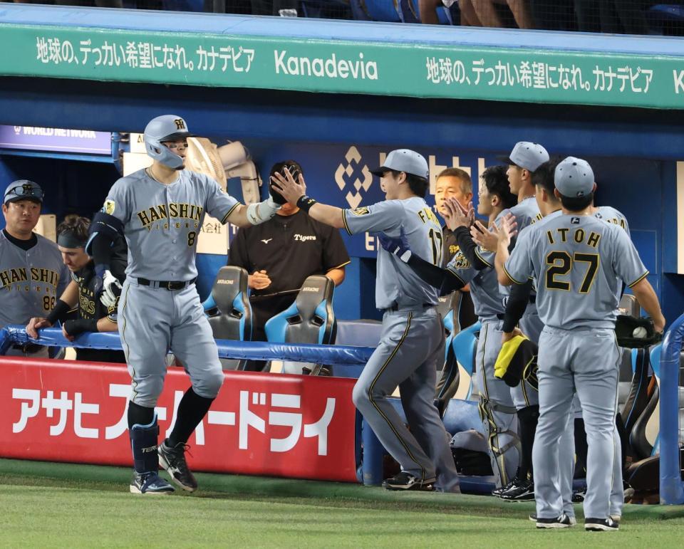 ３回、右中間にソロを放ちナインに迎えられる佐藤輝（撮影・金田祐二）