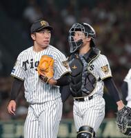 ８回を投げ終えベンチに戻る石井。右は坂本（撮影・西田忠信）